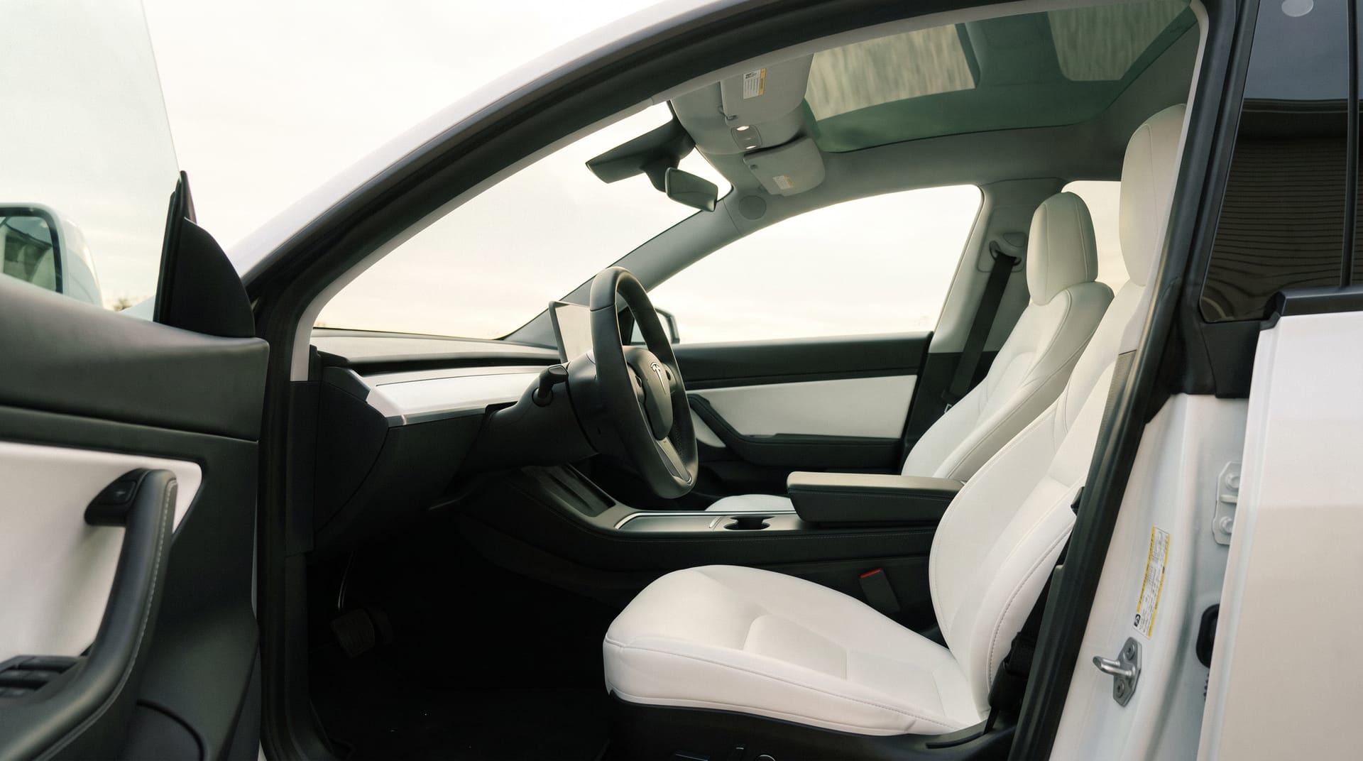 Wit interieur van een Tesla Model Y na reiniging, stuur in beeld