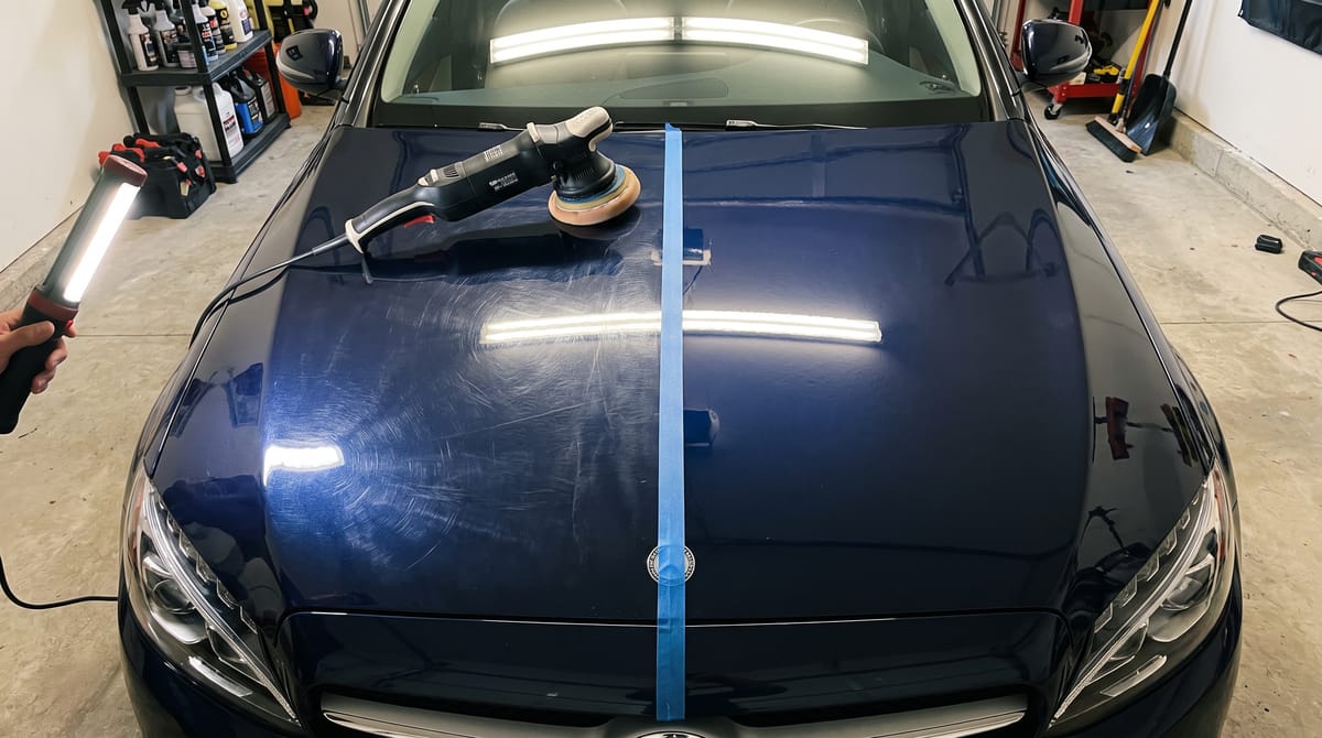Polijstmachine op donkerblauwe lak, links swirls onder inspectielicht, rechts spiegelglans